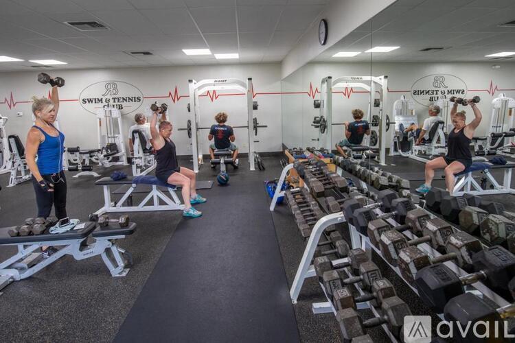 A gym with people working out and a sign that says "Swim & Tennis Club".