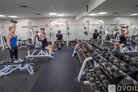 A gym with people working out and a sign that says "Swim & Tennis Club".