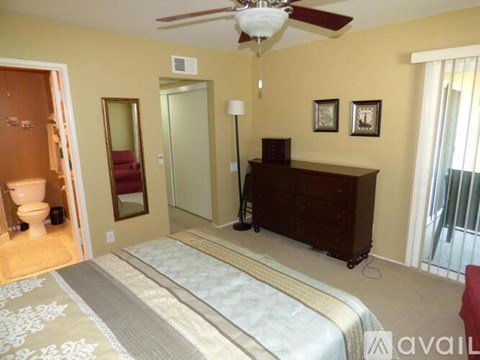 A bedroom with a bed, dresser, and mirror.