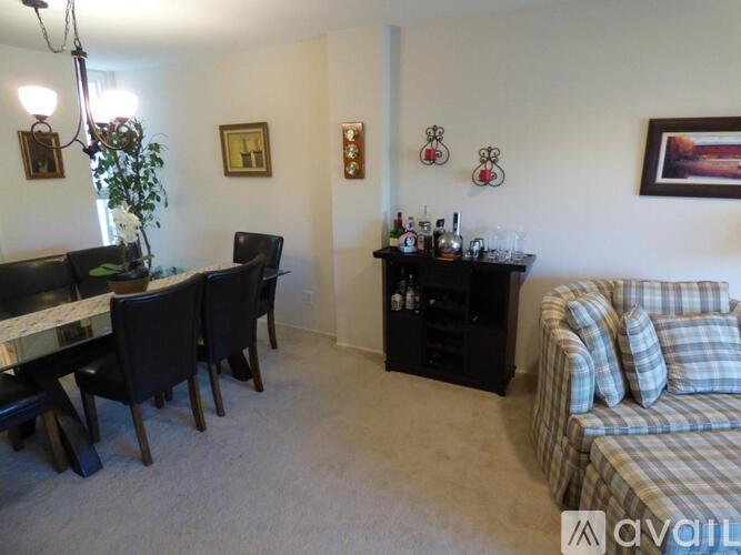 A living room with a couch, a dining table, and a bar area.