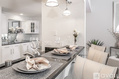 A modern dining room with a glass table and chairs.