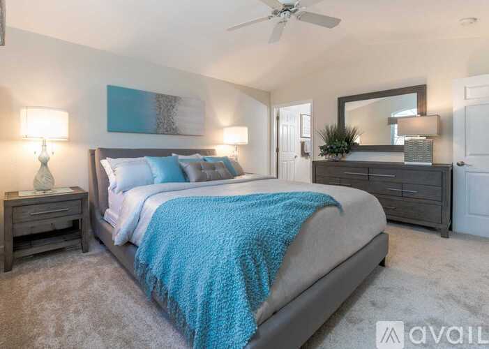 A bedroom with a large bed and a ceiling fan.