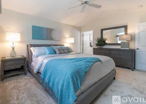A bedroom with a large bed and a ceiling fan.