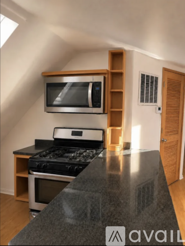 A kitchen with a black countertop and a stove top oven.