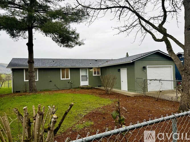 A house with a green roof and white garage door.
