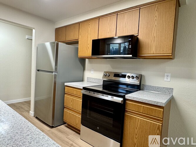 A kitchen with a stainless steel refrigerator, microwave, oven, and dishwasher.