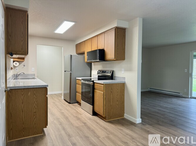 A kitchen with wooden cabinets and a granite countertop.
