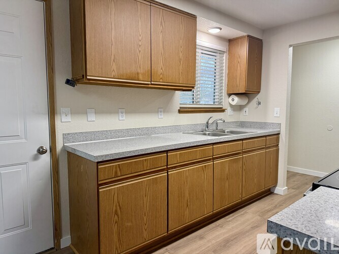 A kitchen with wooden cabinets and a granite countertop.