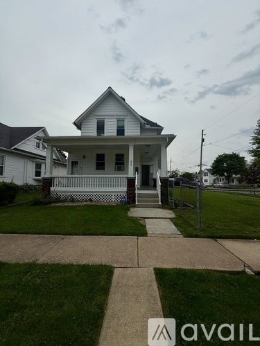A white house with a porch and a sign that says "avail".