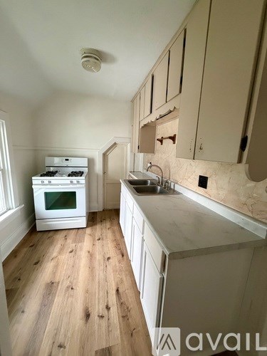 A kitchen with wooden floors and white appliances.