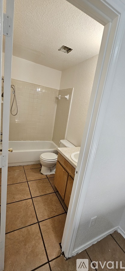 A bathroom with a toilet, sink, and shower.