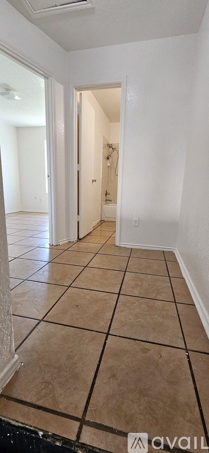 A room with a tiled floor and a doorway leading to another room.