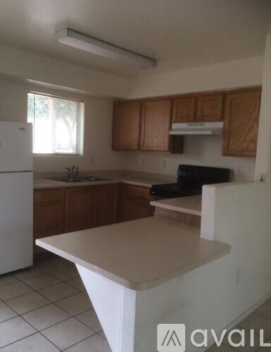 A kitchen with a white fridge and wooden cabinets.
