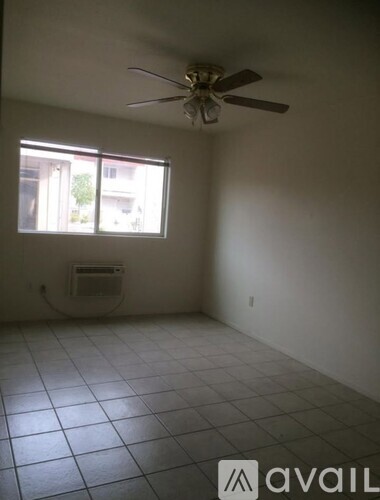 A room with a ceiling fan and a window.
