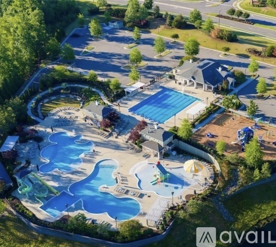 An aerial view of a water park with a large blue pool and a smaller pool with a waterfall.