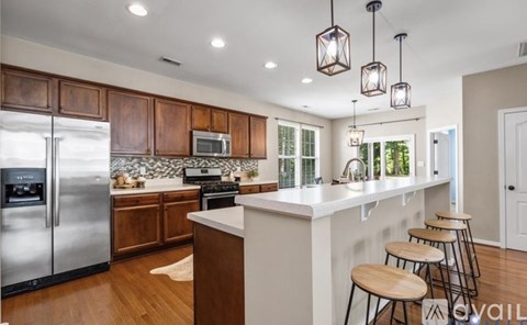 A kitchen with wooden cabinets and a white island.