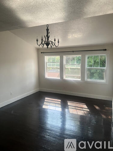 A room with a chandelier and a window with a view of a building outside.