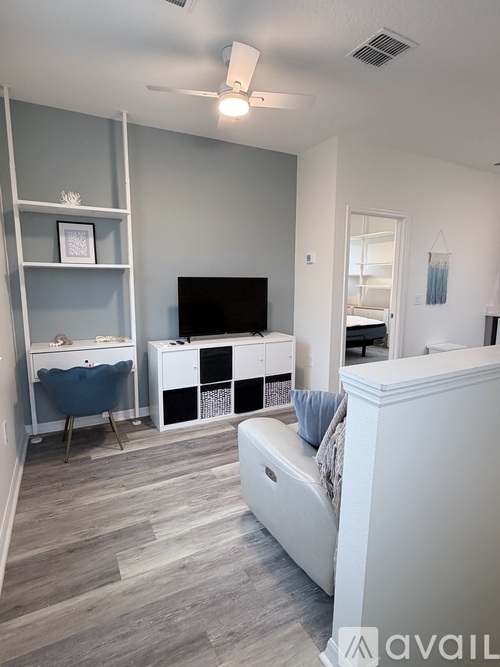 A living room with a white couch and a television.
