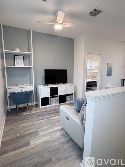 A living room with a white couch and a television.