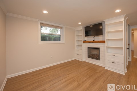 A living room with a fireplace and a television mounted above it.