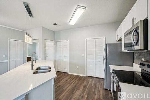 A kitchen with white countertops and a microwave above the stove.