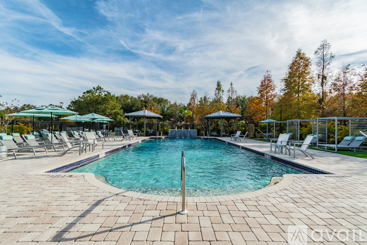 A large outdoor swimming pool surrounded by lounge chairs and umbrellas.