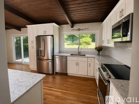 A kitchen with a refrigerator, sink, and cabinets.