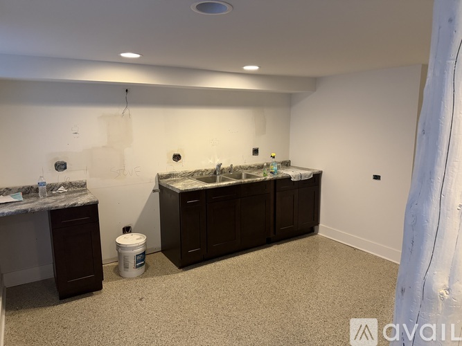 A room with a counter and a trash can.