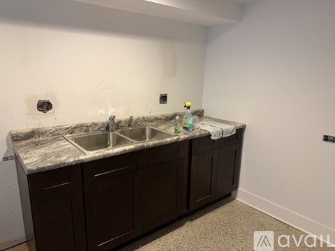 A kitchen with brown cabinets and a marble countertop.