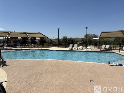 A large outdoor swimming pool with sun loungers and a canopy.
