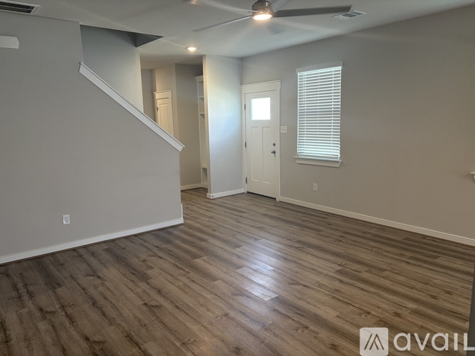A room with wooden flooring and a ceiling fan.