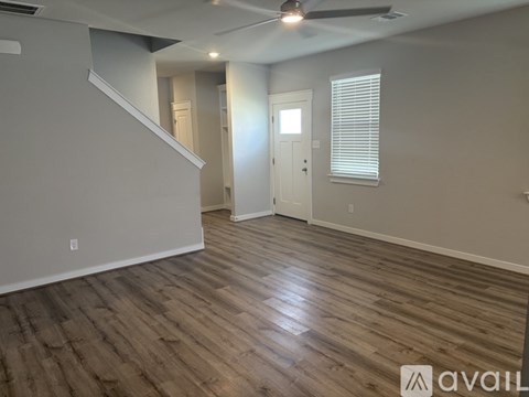 A room with wooden flooring and a ceiling fan.