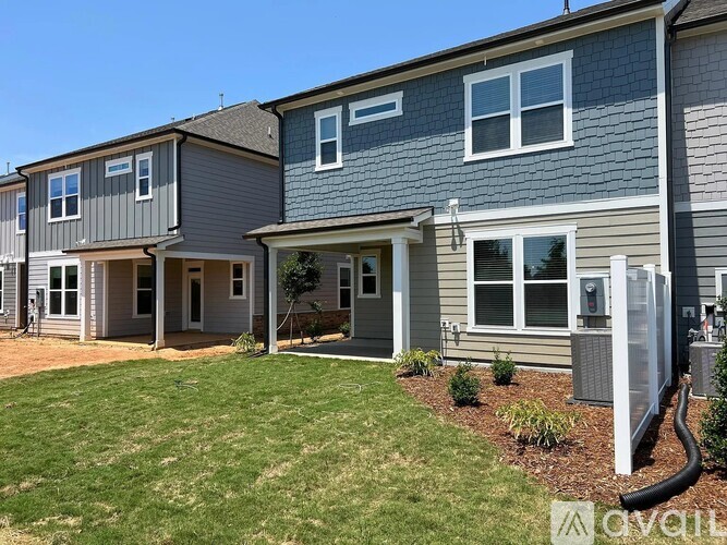 A row of houses with a grassy front yard.