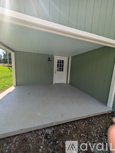 A covered porch with a white door and a window.