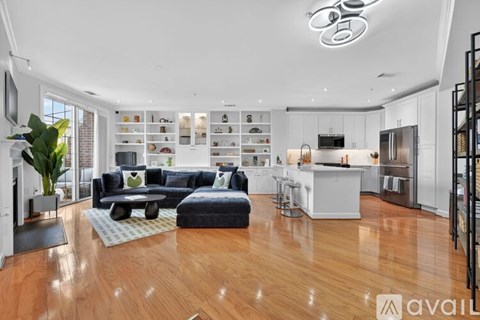 A modern living room with a dark blue sofa and a wooden floor.