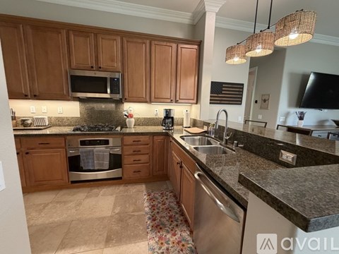 A kitchen with wooden cabinets and granite countertops.
