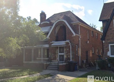 A house with a red brick exterior and a white porch.