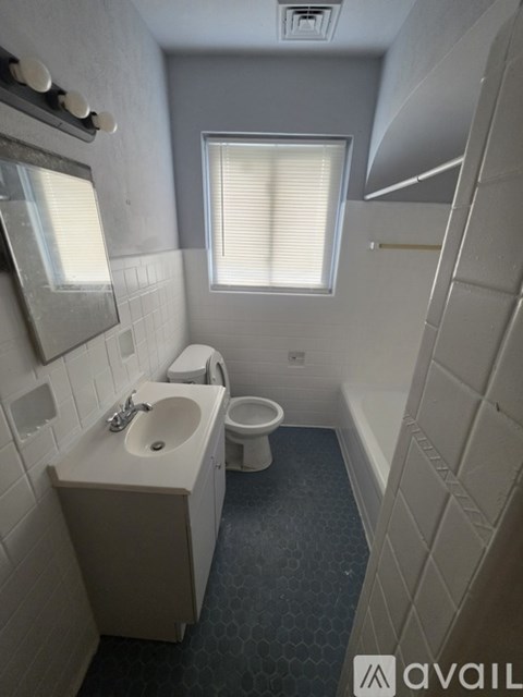 A bathroom with a sink, toilet, and a window.
