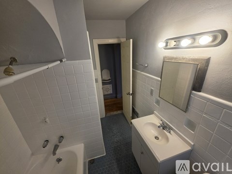 A bathroom with a white sink and a white bathtub.