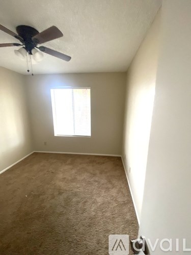 A room with a ceiling fan and a window.