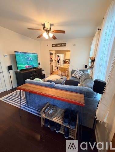 A living room with a television and a sofa.