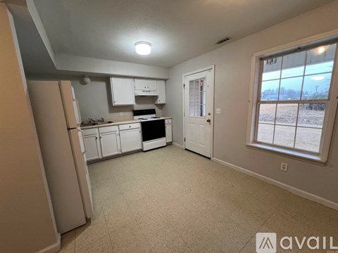 A kitchen with white appliances and cabinets is available for rent.