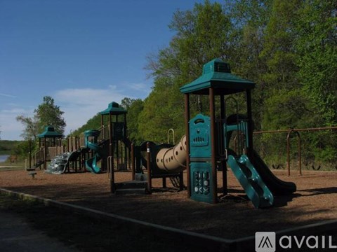 A playground with a green slide and a wooden structure.
