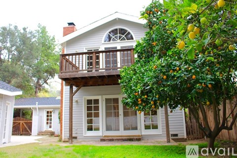 A house with a lemon tree in front.