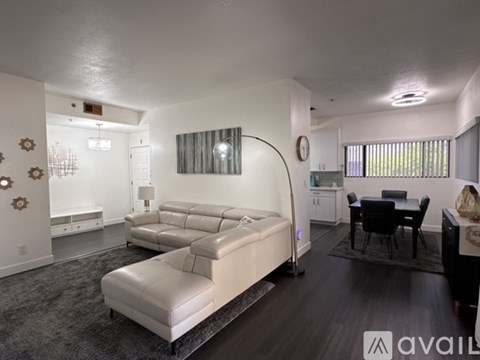 A living room with a white sofa and a black dining table.