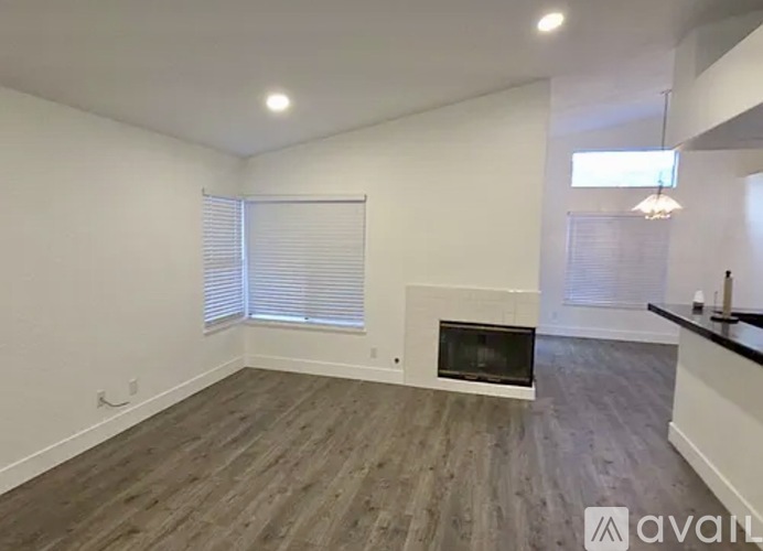 A room with a fireplace and wooden flooring.