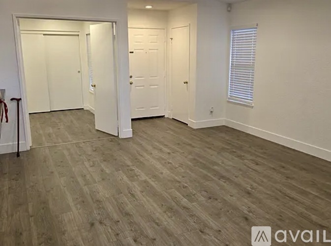 A room with wooden flooring and two white doors.