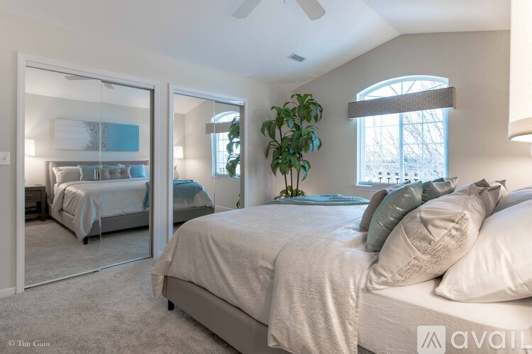 A bedroom with a large bed and a mirror on the wall.
