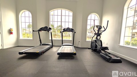 A gym with treadmills, elliptical machines, and a weight machine.