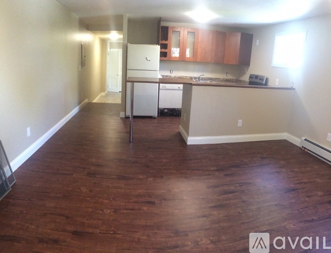 A kitchen with wooden floors and white appliances.